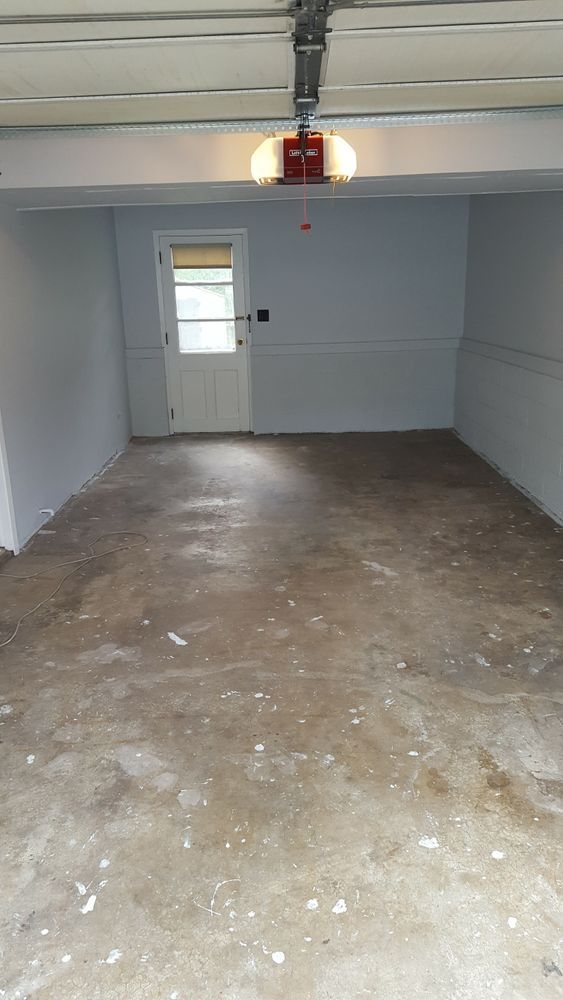 An empty garage with a door and a garage door open