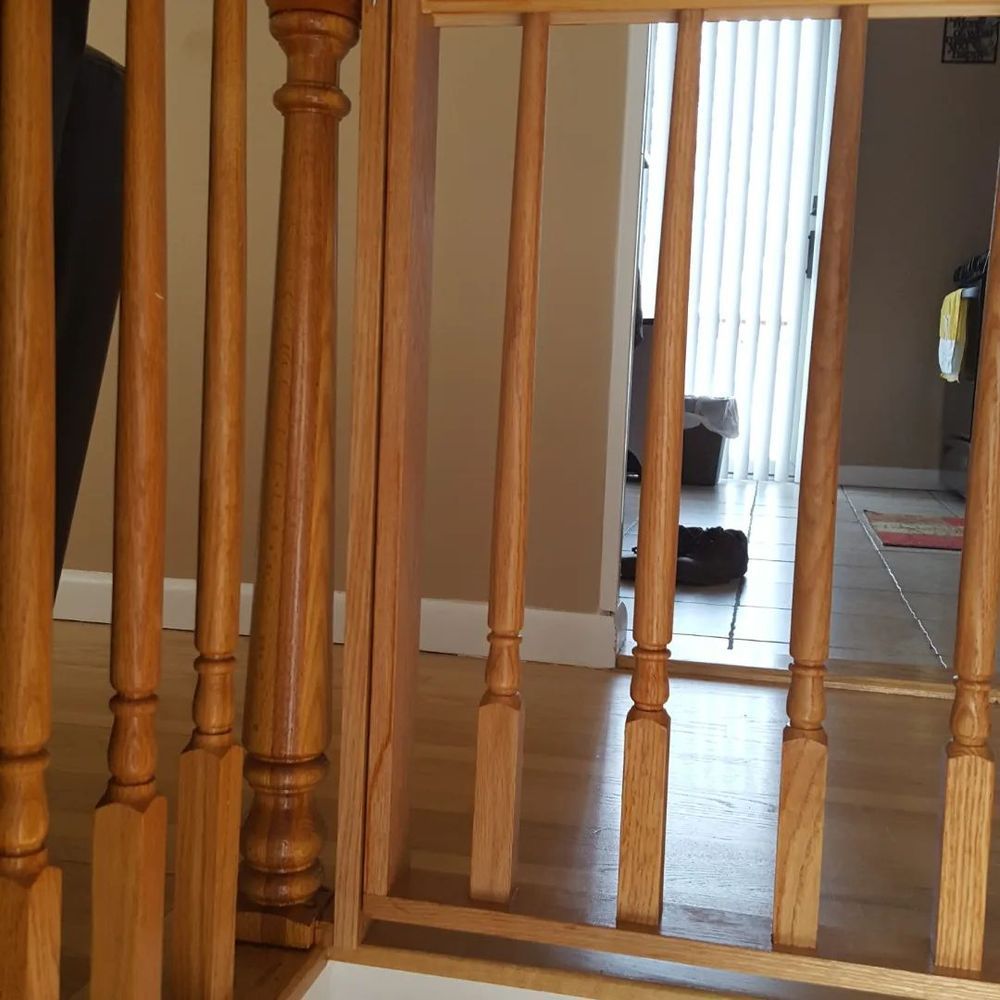 A wooden staircase with a door in the background