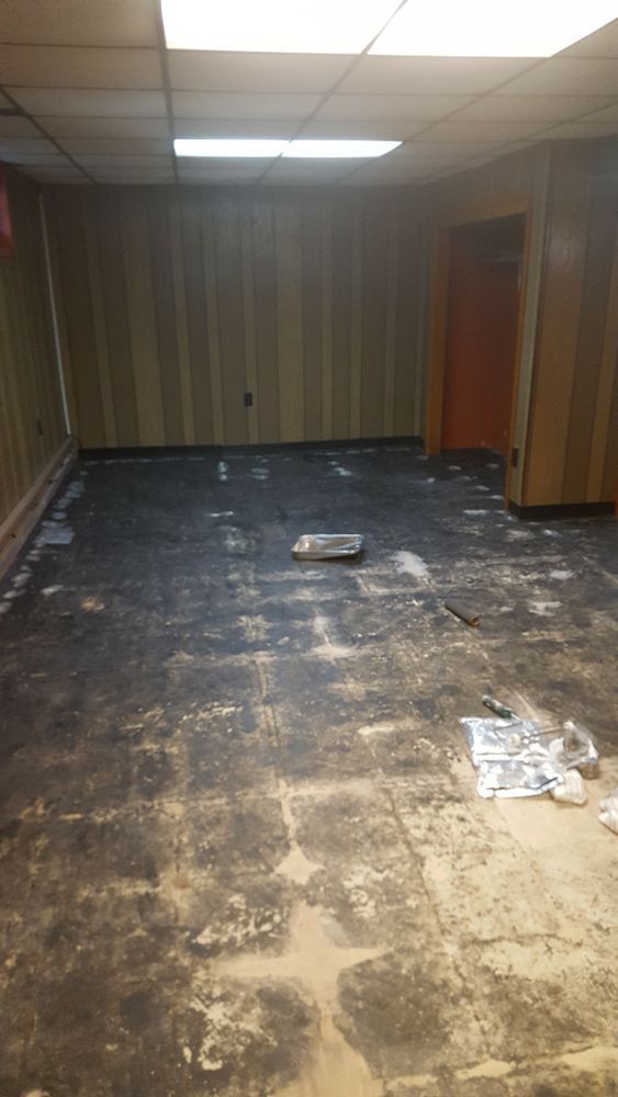 A room with a dirty floor and a door