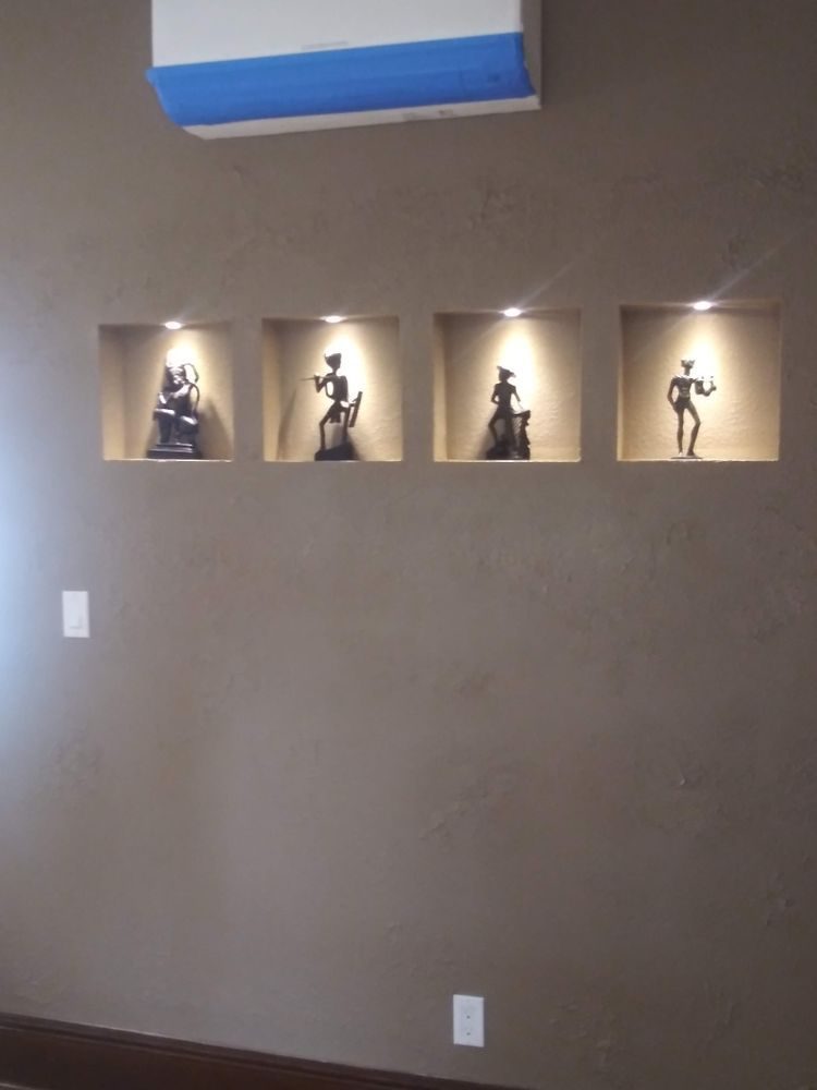 A wall with four niches with statues in them