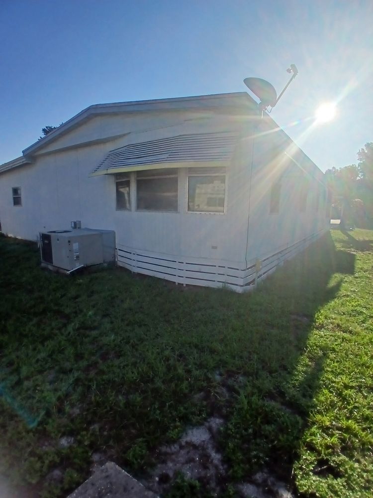 A white mobile home with a satellite dish on top of it