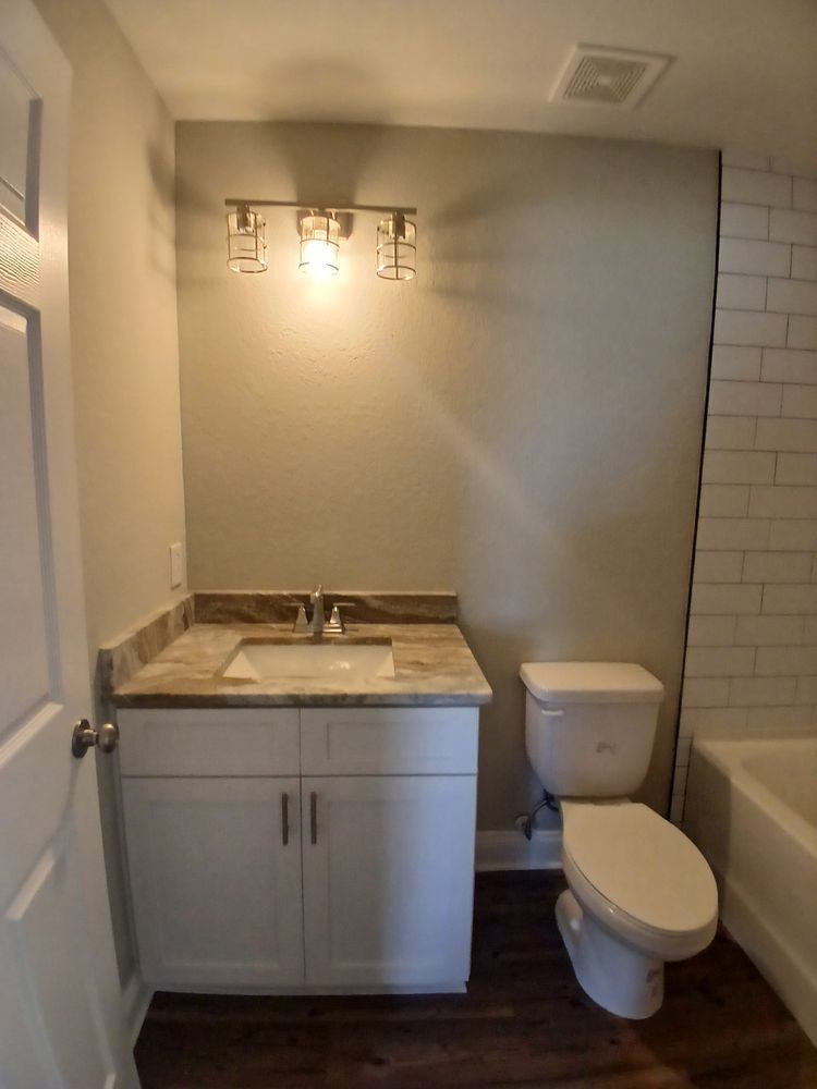 A bathroom with a sink , toilet and bathtub.