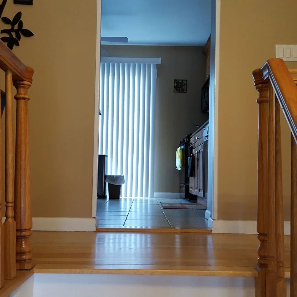 A wooden staircase leading up to a kitchen
