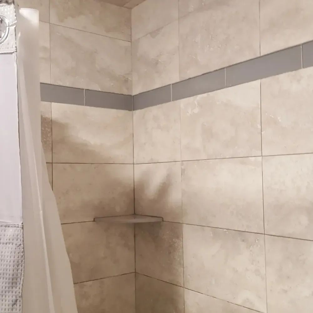A bathroom with a shower curtain and a shelf