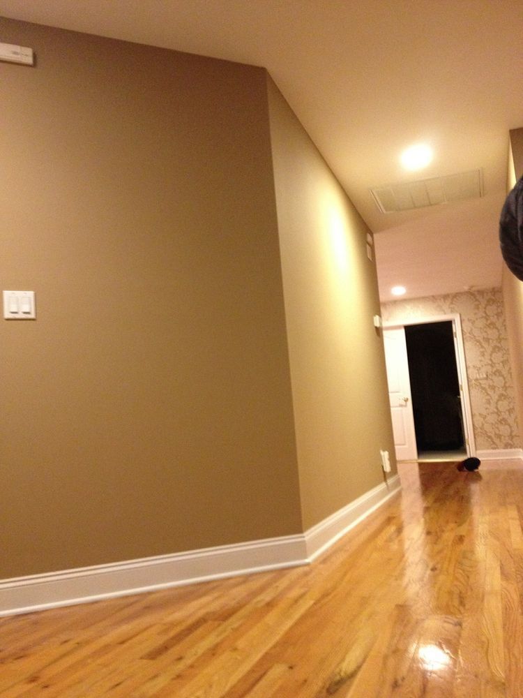 A hallway with hardwood floors and tan walls