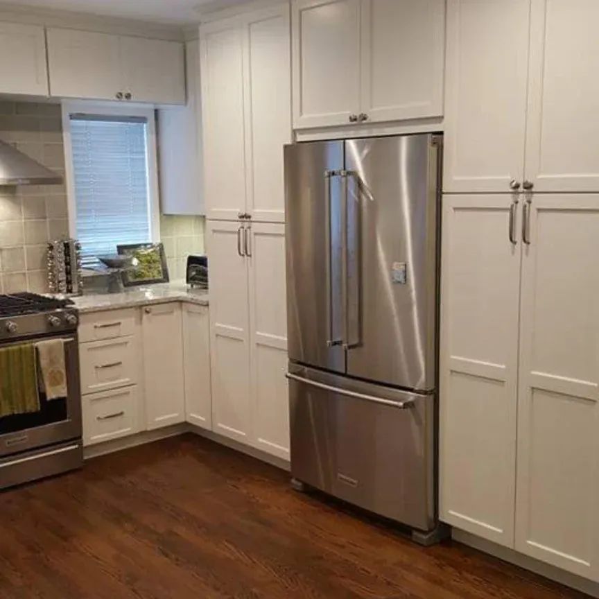 A kitchen with stainless steel appliances and white cabinets