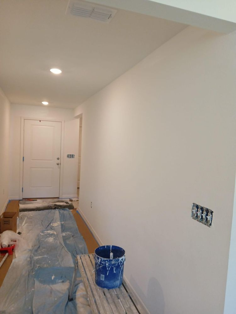 A bucket of paint is sitting on a table in a hallway.