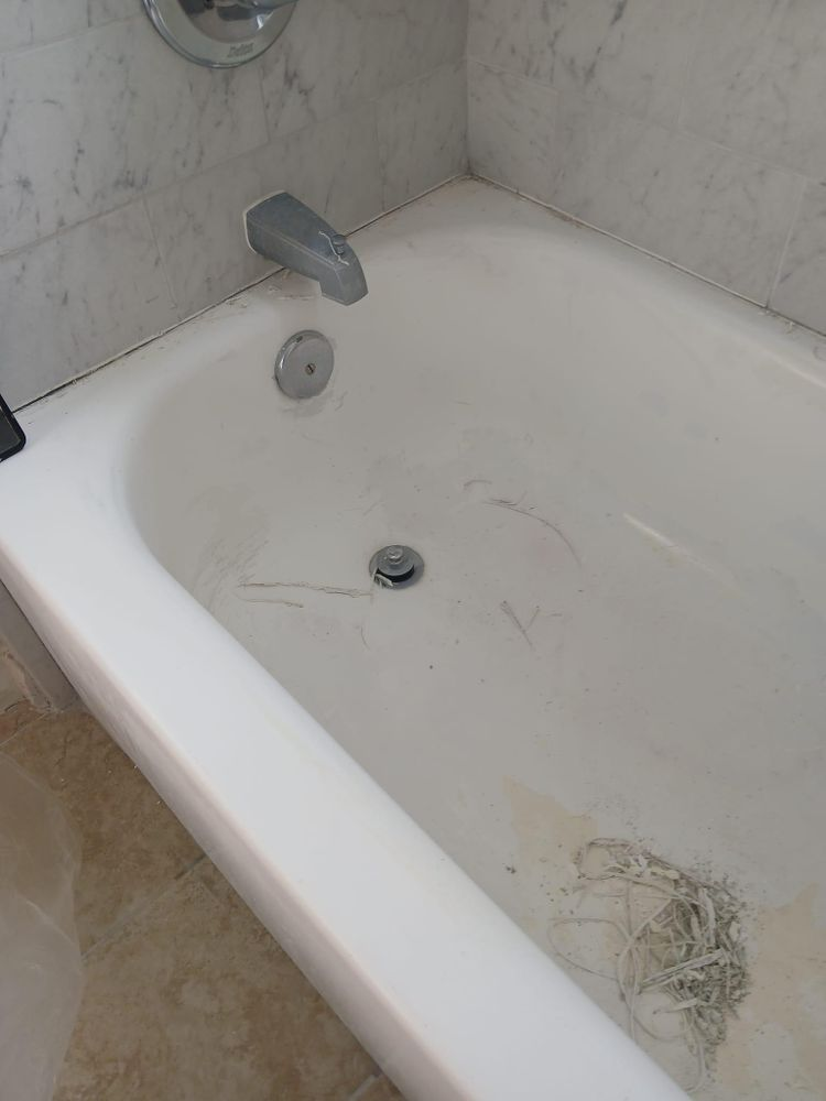 A white bathtub is sitting in a bathroom next to a marble wall