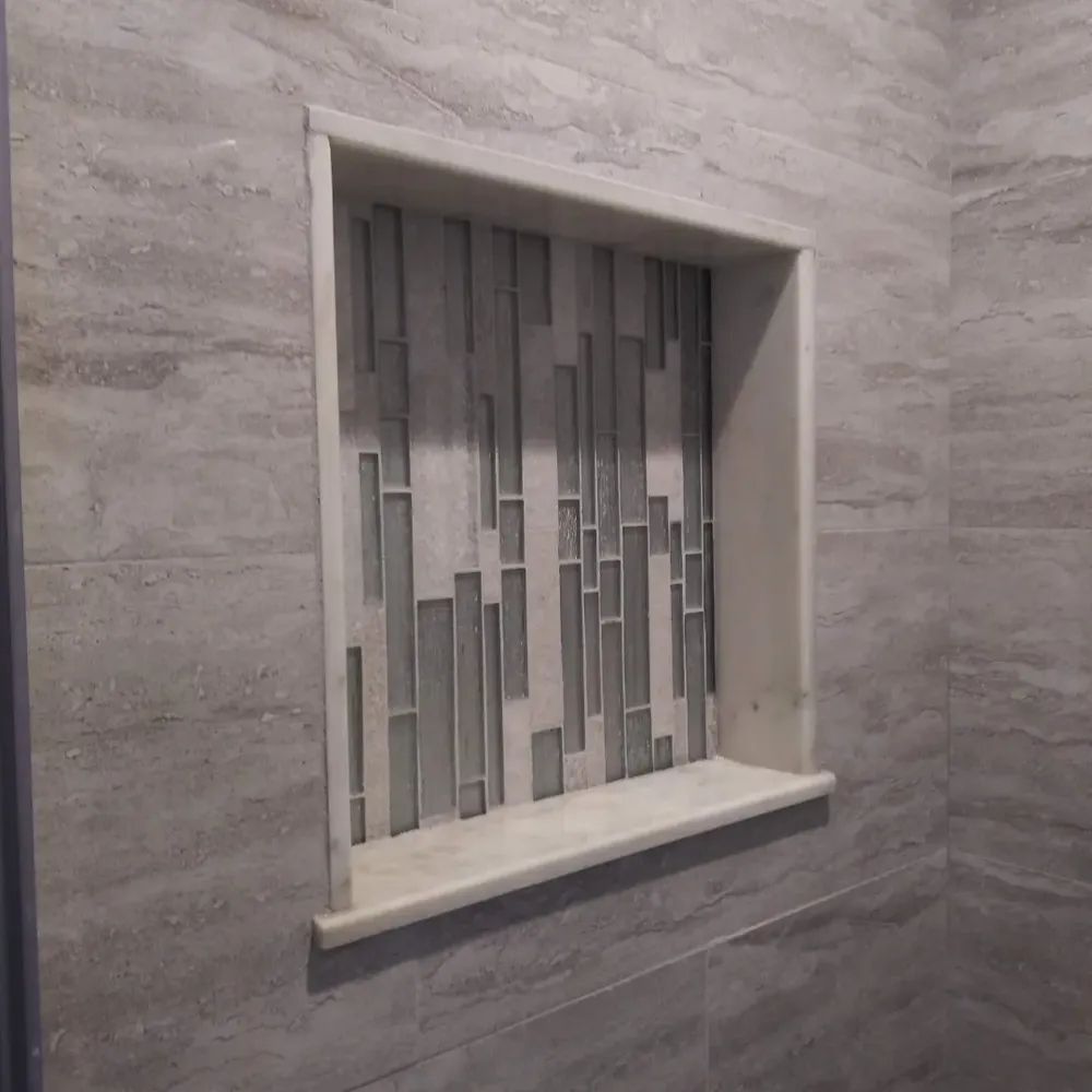A shower stall with a window and a shelf in it