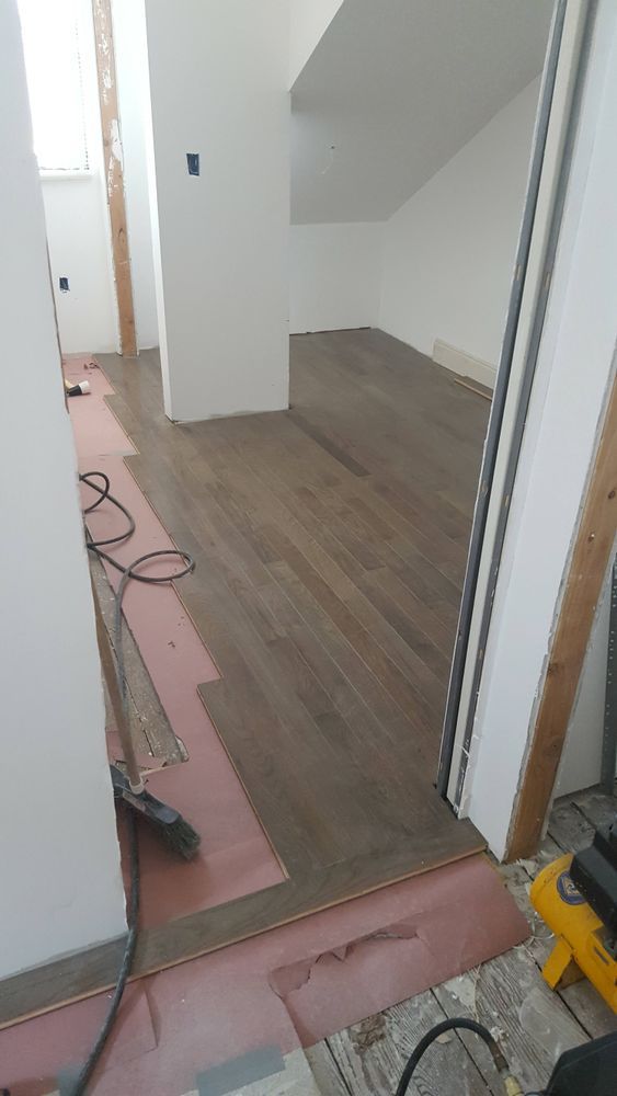 A wooden floor is being installed in a room.