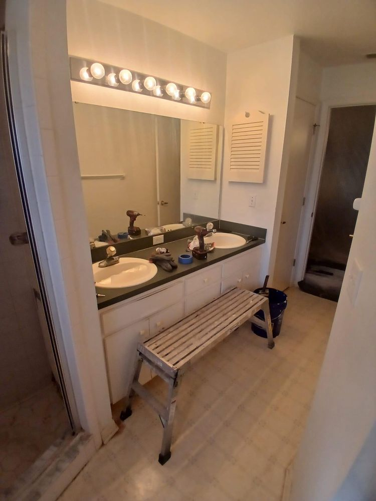 A bathroom with two sinks and a bench