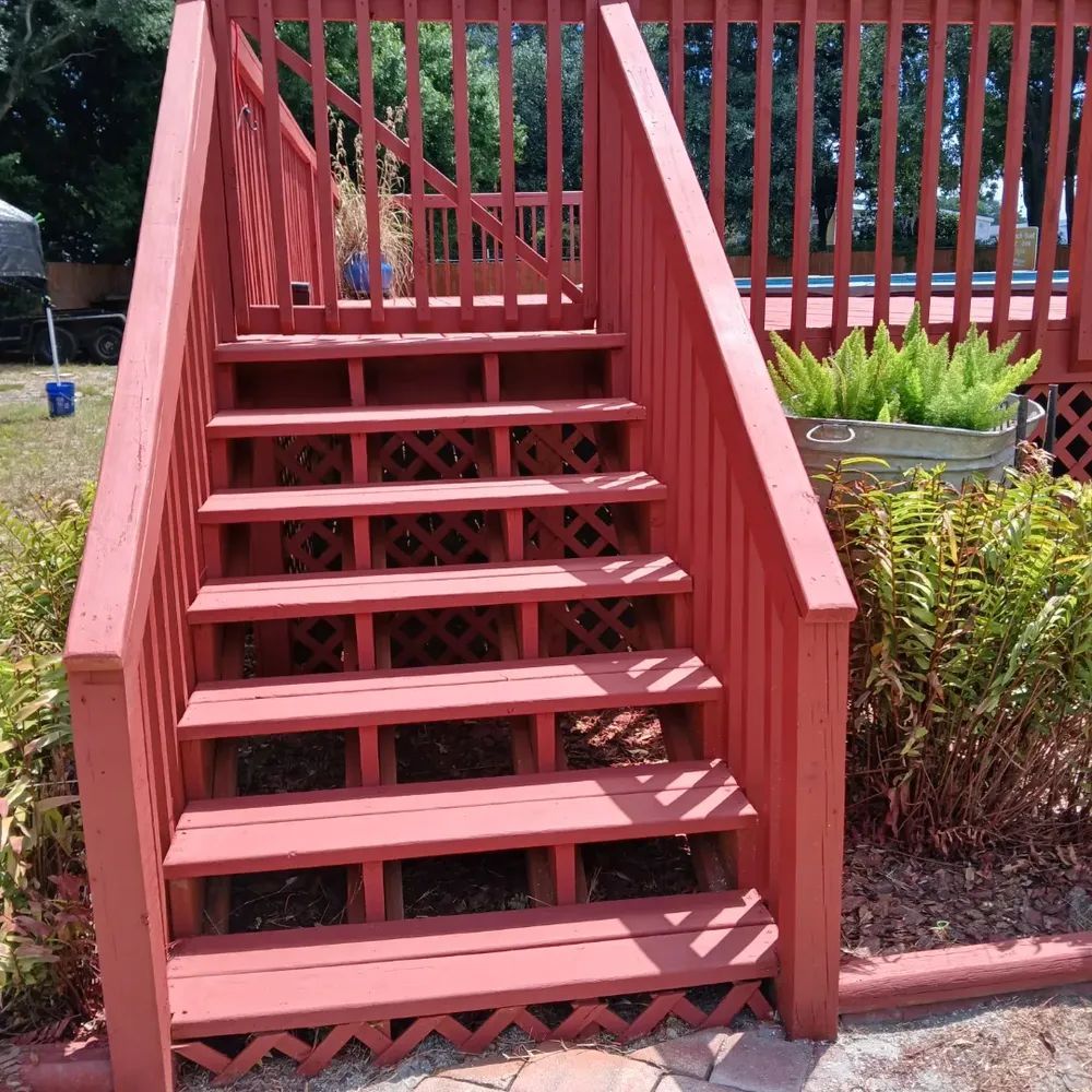 A set of red wooden stairs leading up to a deck