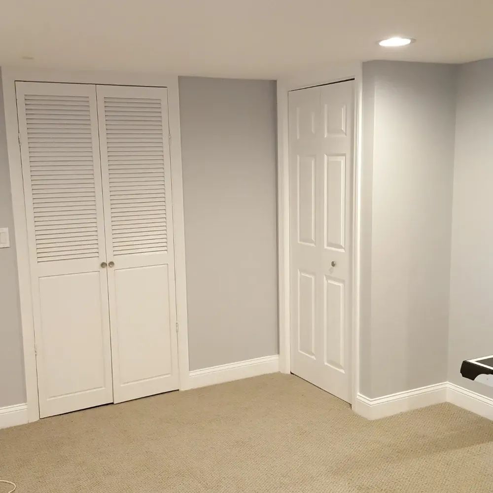 An empty room with a closet and two doors
