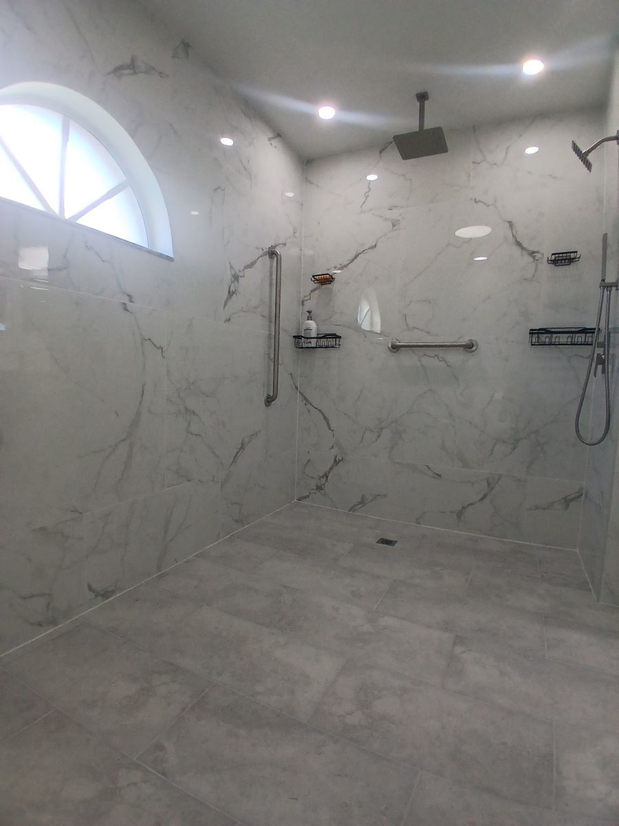 A bathroom with a walk in shower and a window