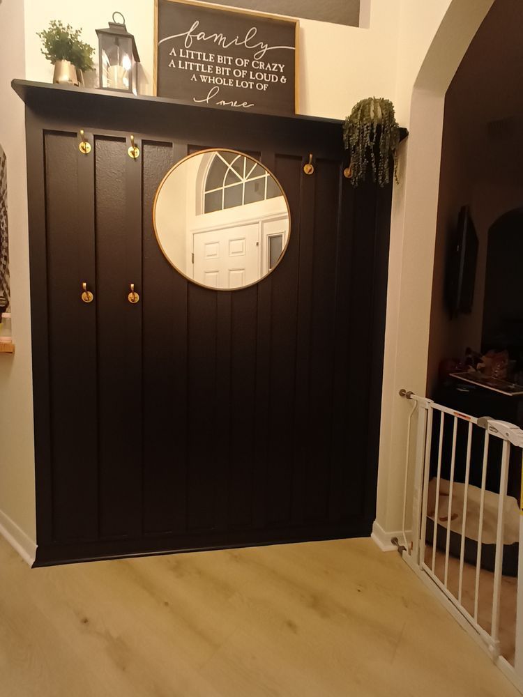 A black wall with a mirror and a sign that says family