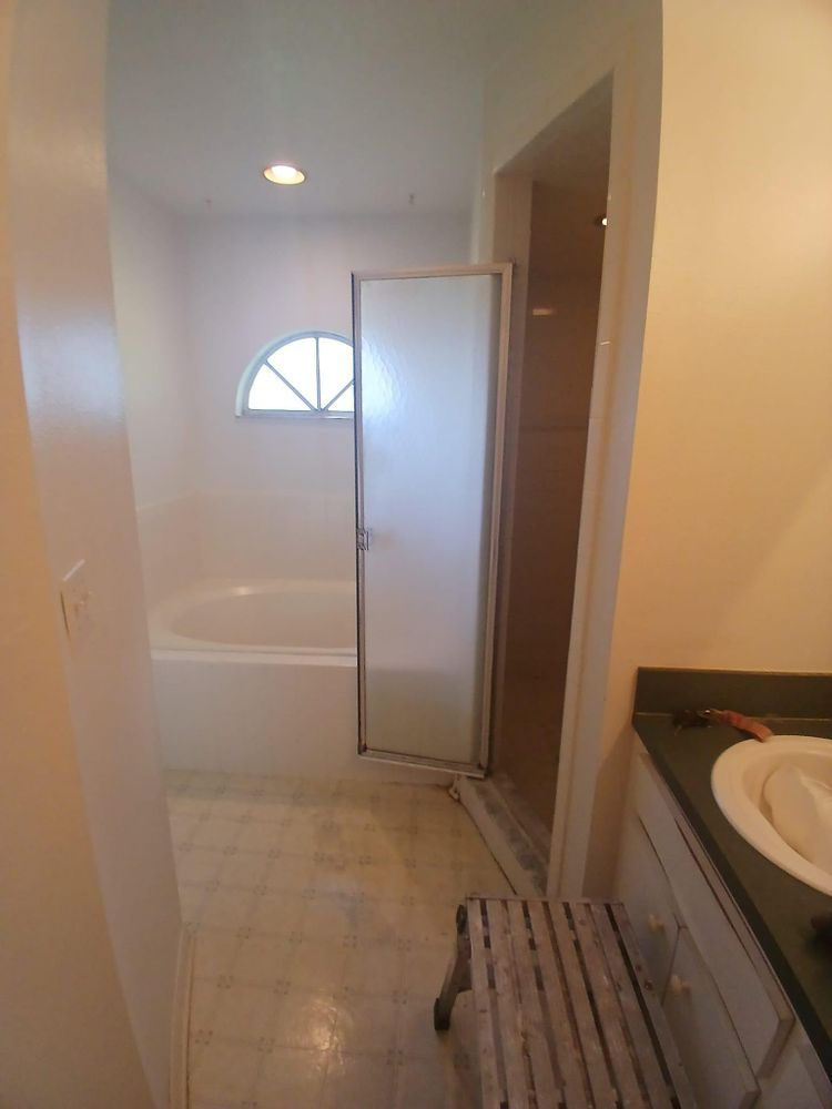A bathroom with a bathtub , sink , and walk in shower