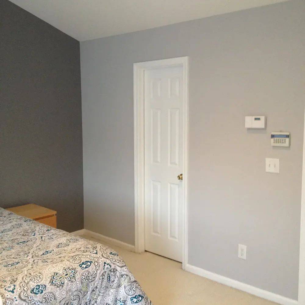 A bedroom with a bed and a white door