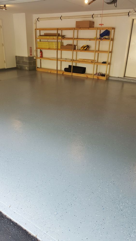 A garage with a gray floor and wooden shelves