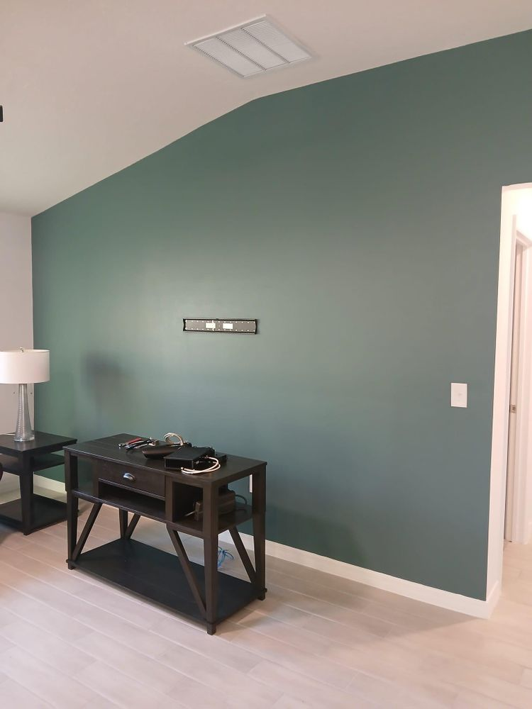 A living room with a green wall and a black table