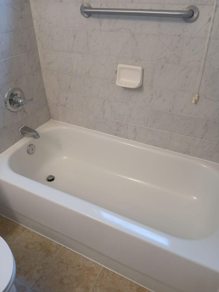 A white bathtub is in a bathroom next to a toilet
