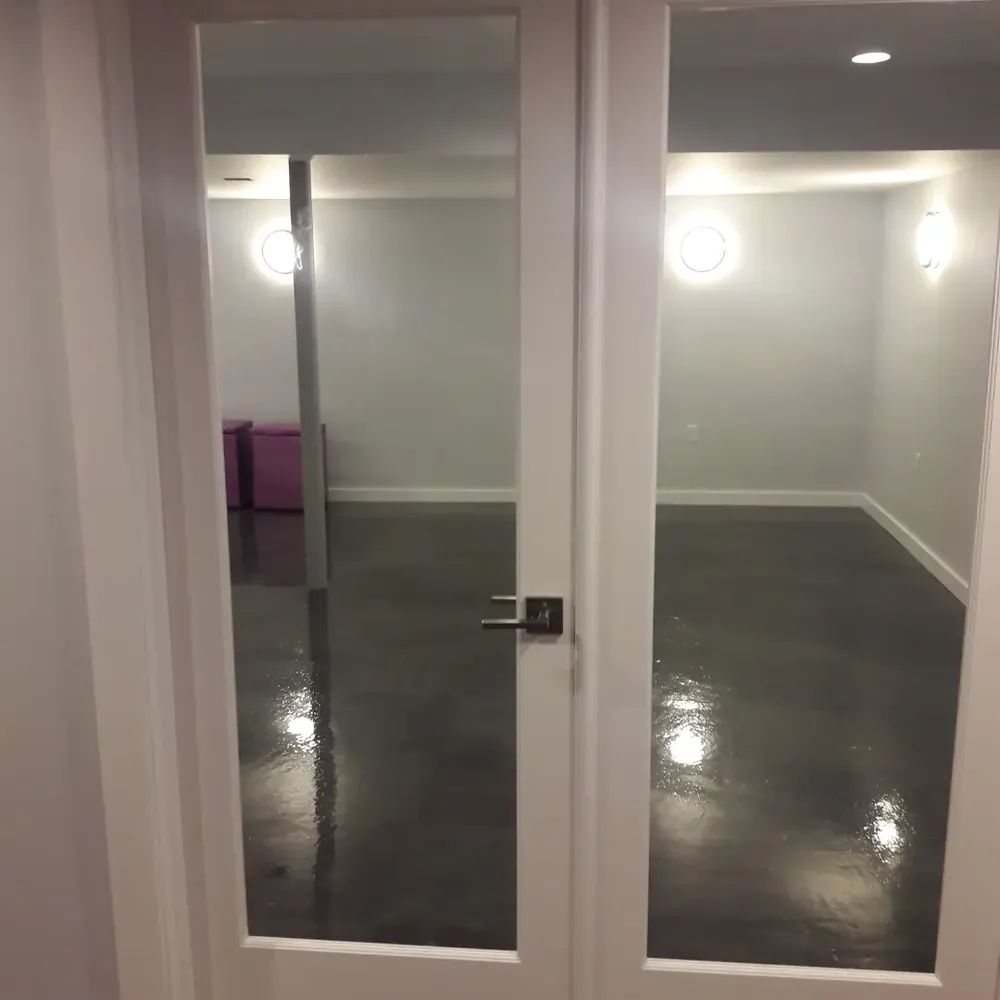 A room with a concrete floor and a glass door