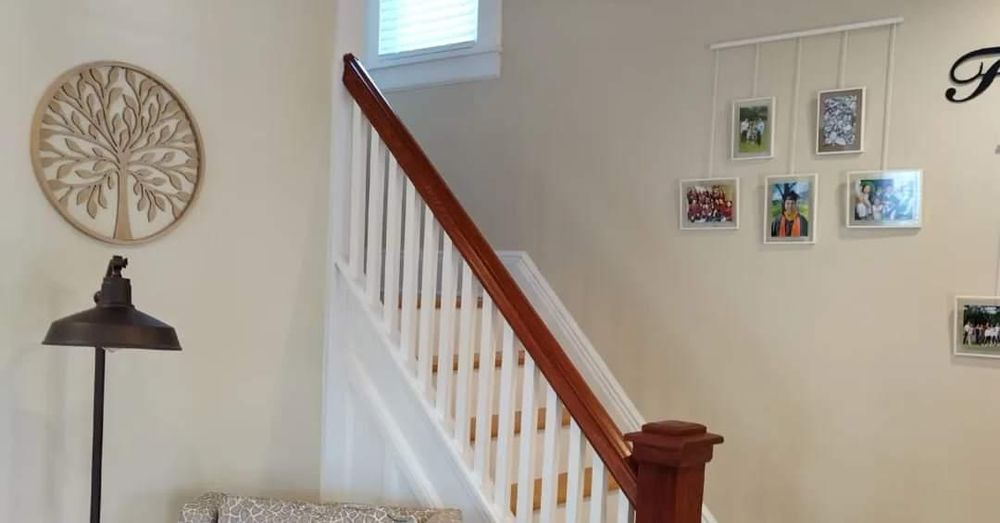 A living room with a staircase leading up to the second floor.