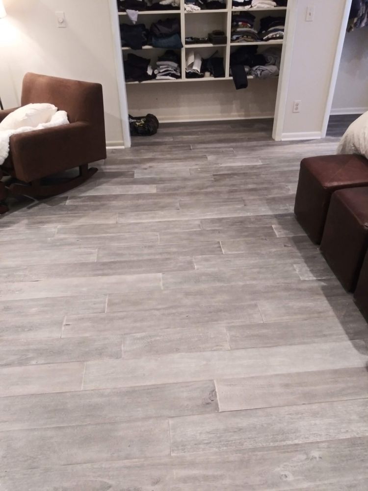 A living room with a rocking chair, couch, and ottomans