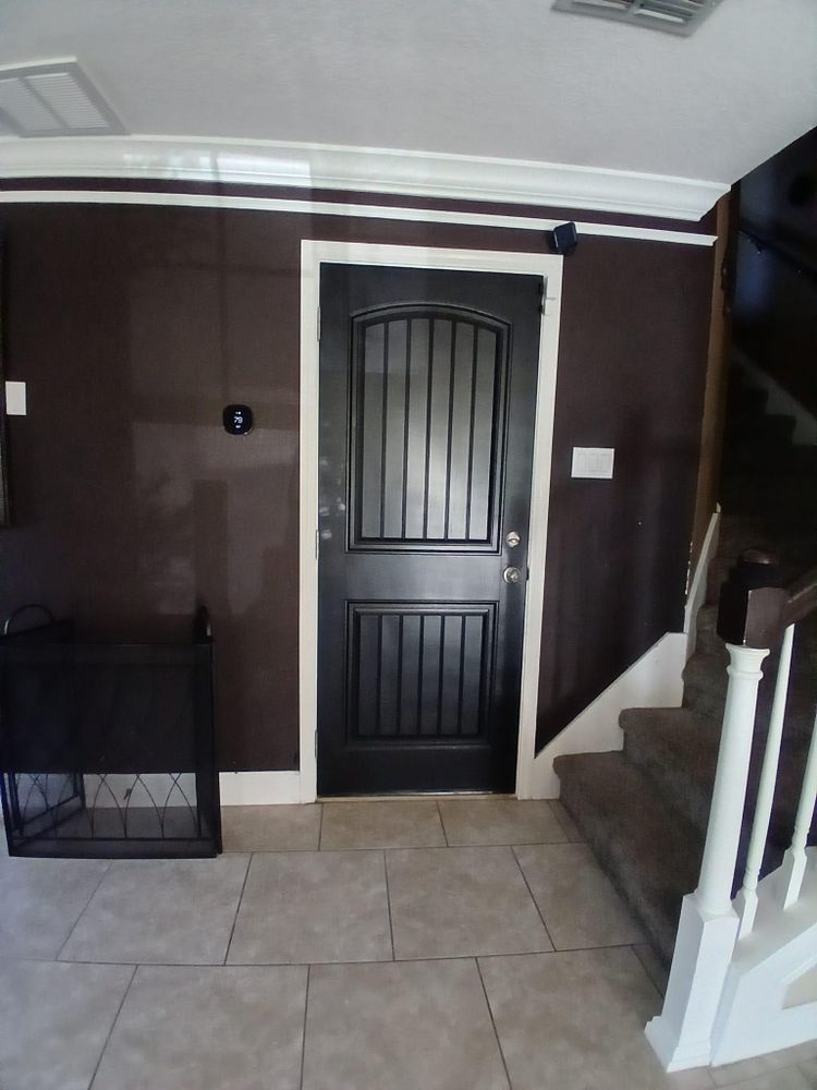 A black door in a hallway next to stairs