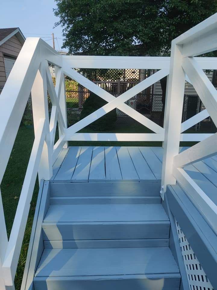 A set of stairs leading up to a deck with a white railing