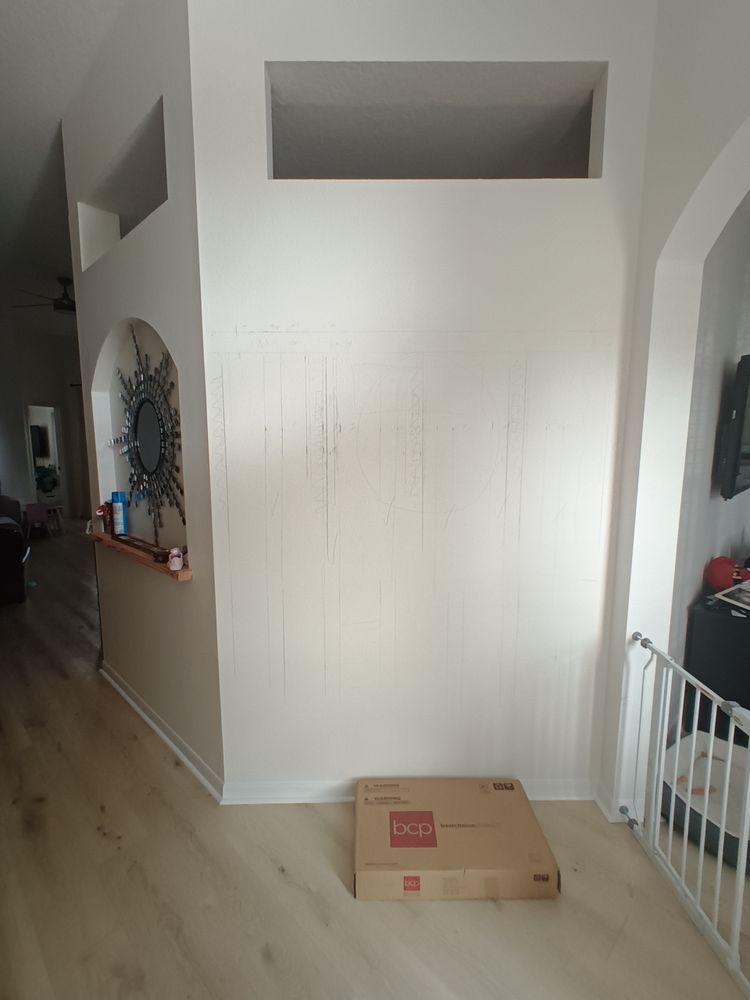 A cardboard box is sitting on the floor in a living room next to a white wall