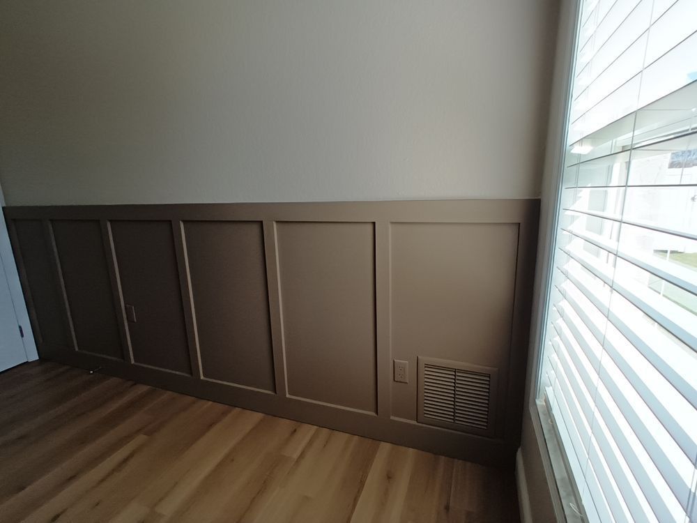 A room with wood paneling and a window with blinds