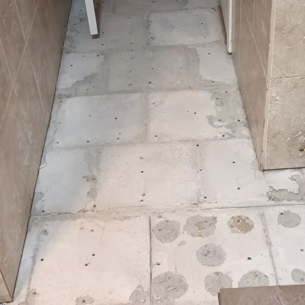 A tiled floor with a white chair in the background