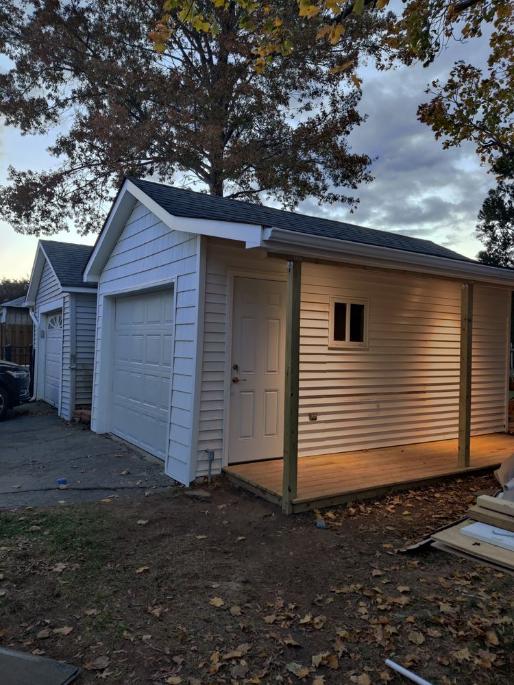A garage with a porch and a car parked in front of it