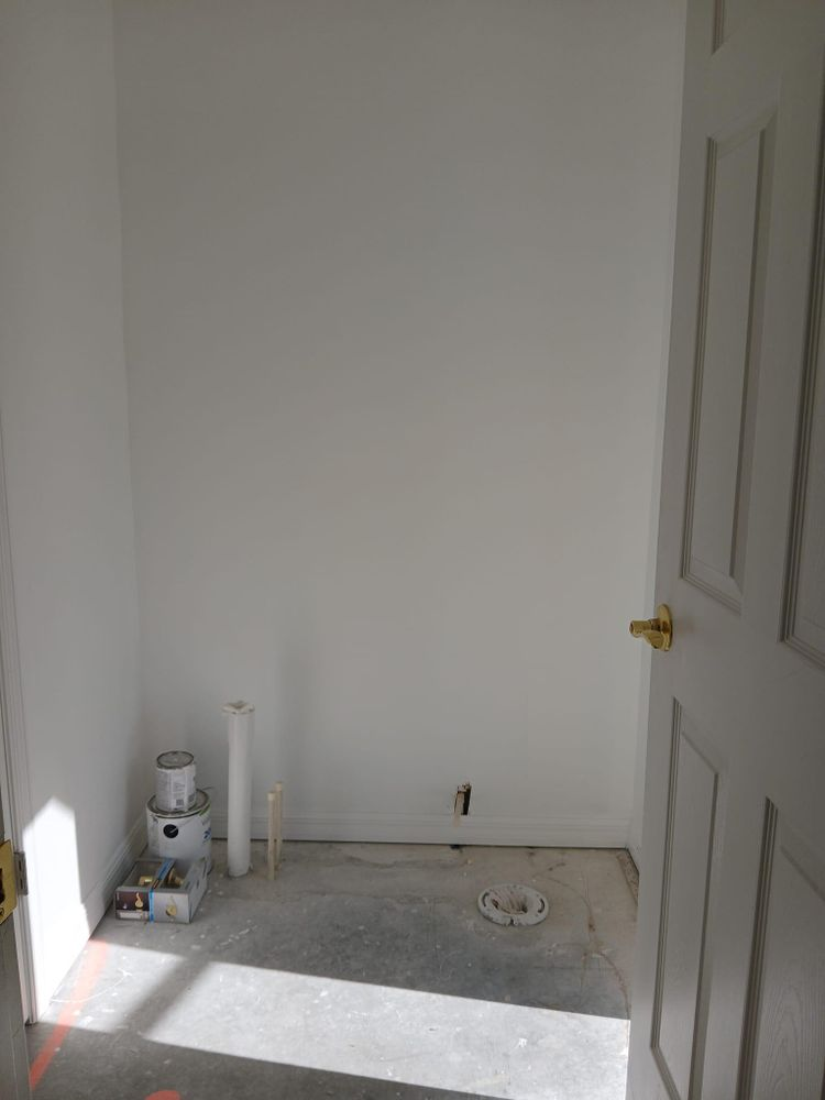 An empty room with white walls and a door