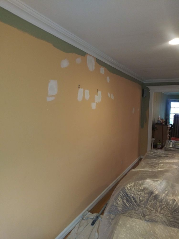 A room with a wall that is being painted.