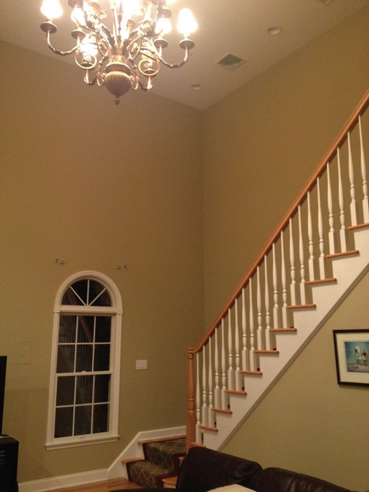 A living room with stairs and a chandelier hanging from the ceiling