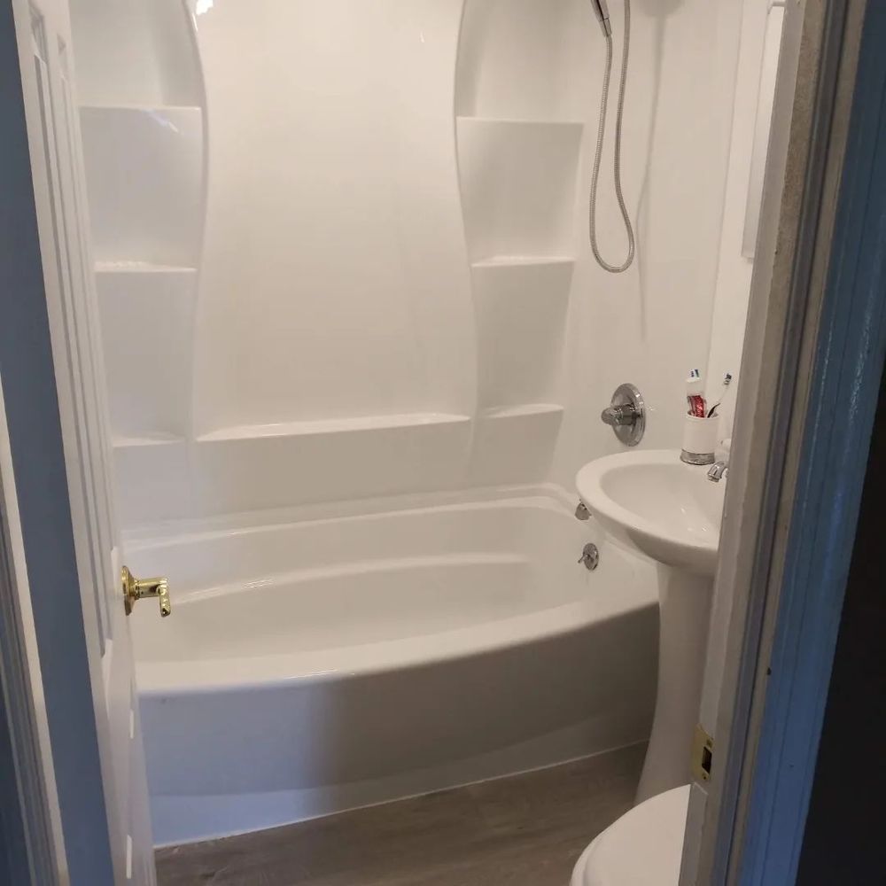 A bathroom with a tub, sink, and shower
