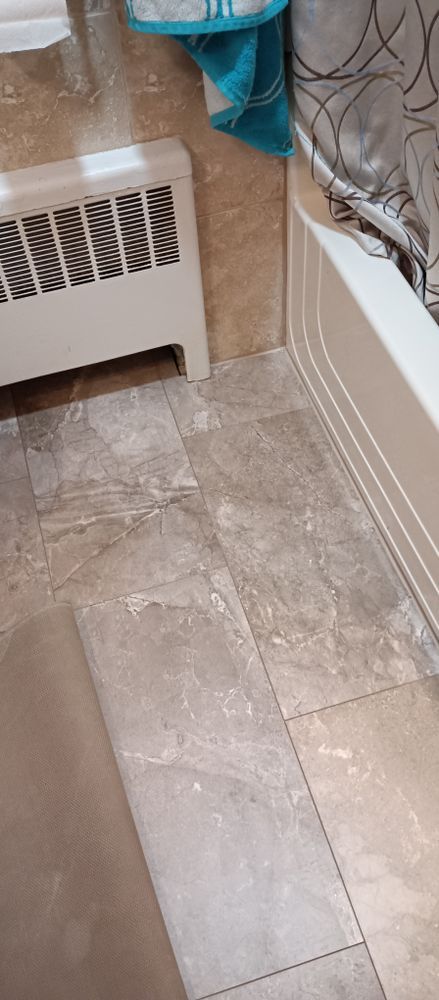 A bathroom with a bathtub and a radiator on the floor