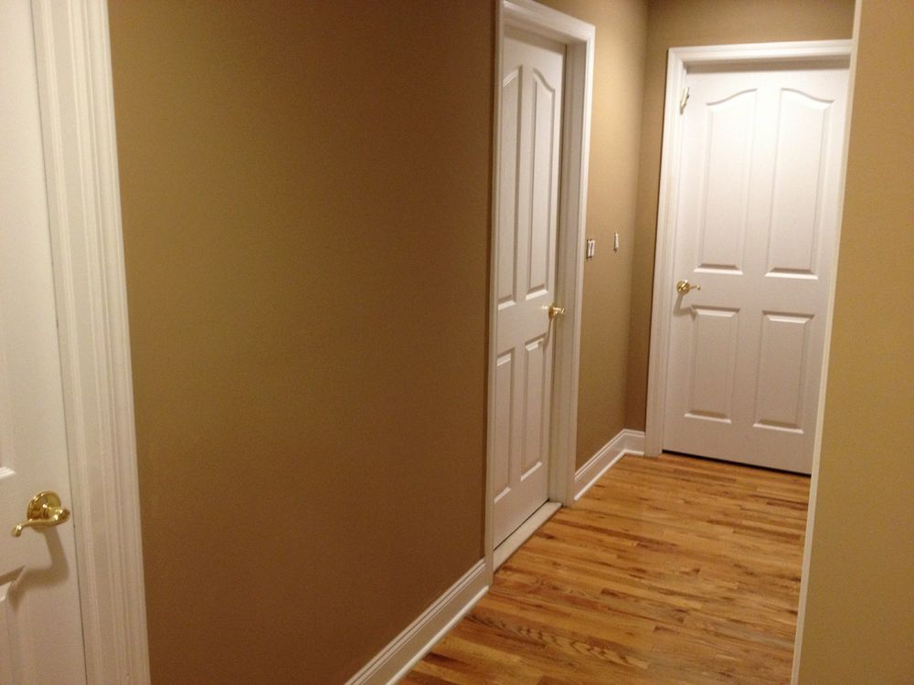 A hallway with hardwood floors and white doors in a house