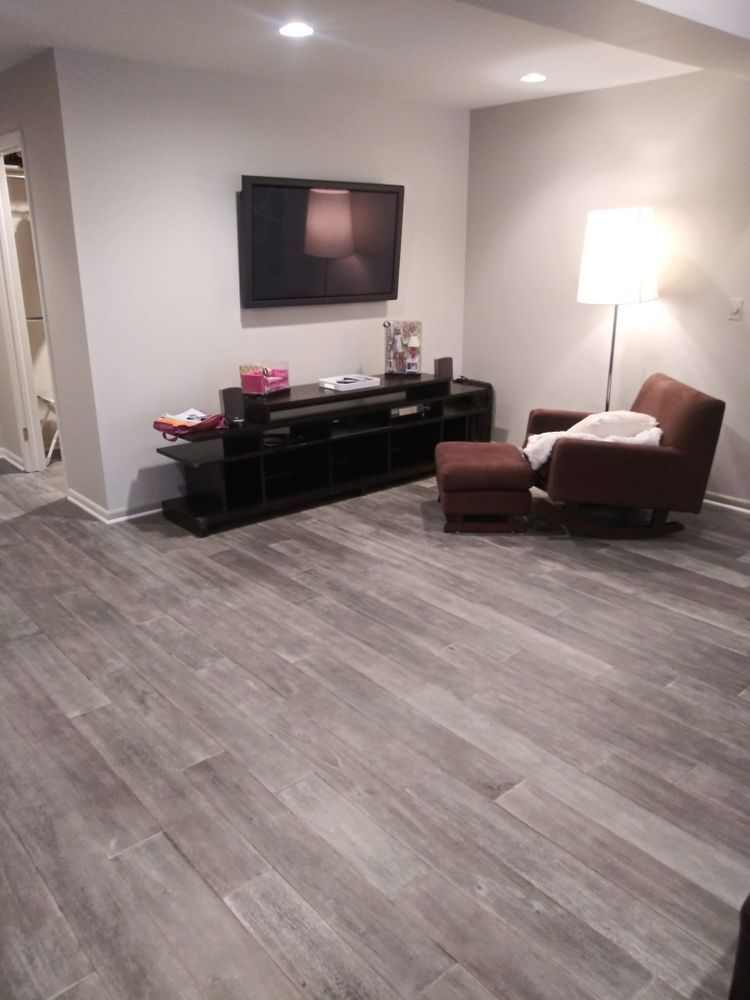 A living room with hardwood floors, a chair and a television