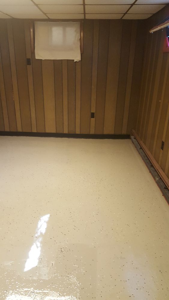 An empty room with wood paneling and a white floor