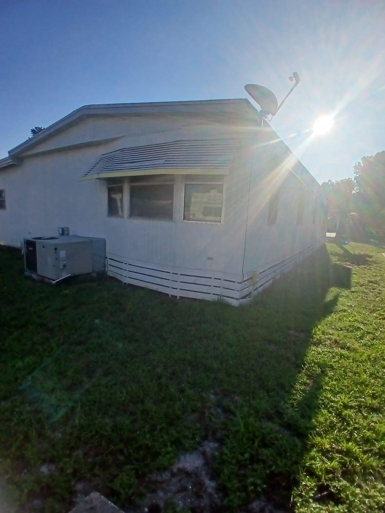 A white mobile home with a satellite dish on top of it