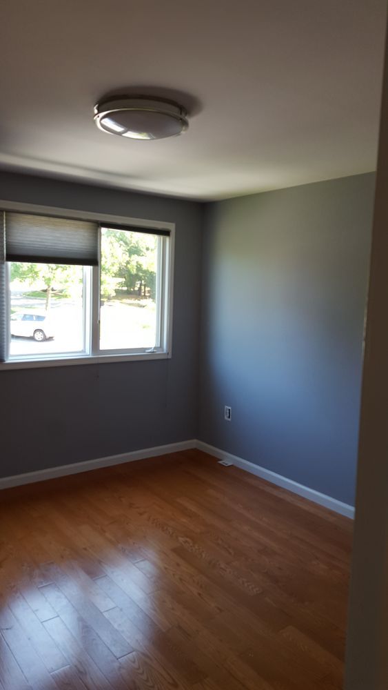 An empty room with hardwood floors and a window