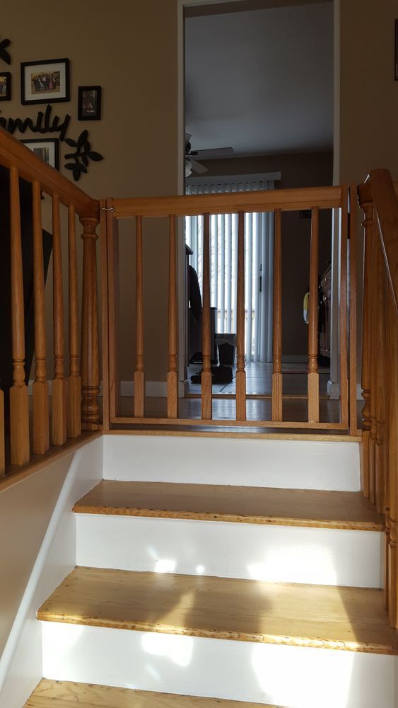 A wooden staircase with white steps and a wooden railing
