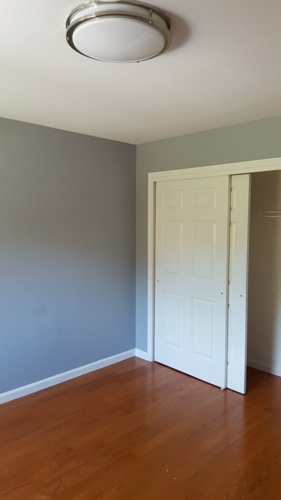 An empty bedroom with hardwood floors and a closet