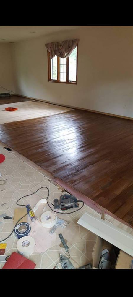 A living room with hardwood floors and a window