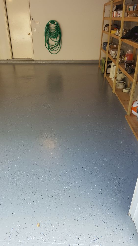 A garage with a hose hanging on the wall and shelves