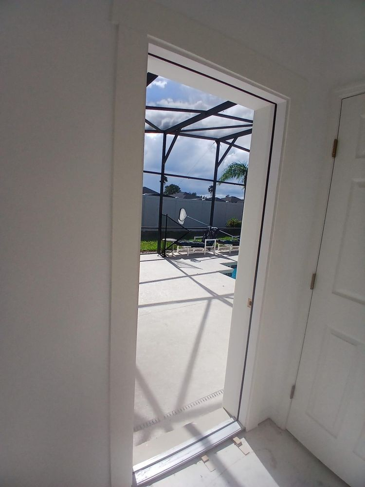 A doorway leading to a screened in patio with a pool