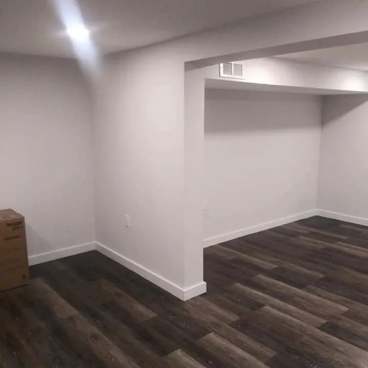 A room with a wooden floor and white walls.