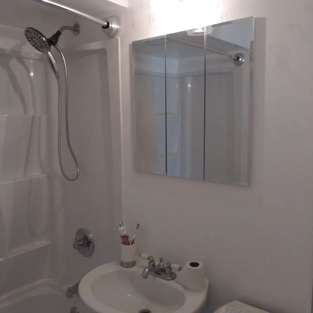 A bathroom with a sink a shower and a mirror